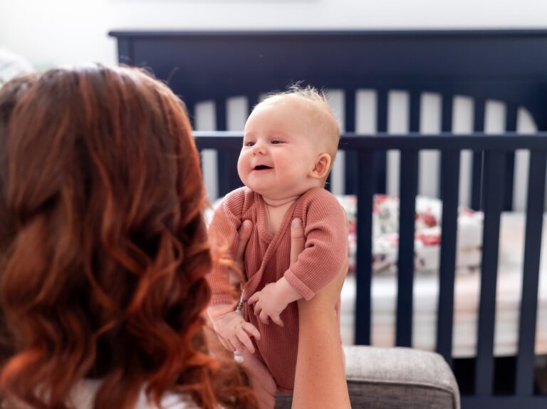 A mom and baby in front a crib